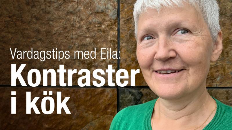 Eila har kort, grått hår och står framför en rostbrun vägg. Hon ser glad  ut.