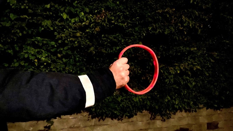 På bilden syns en jackärm med en reflex som håller i en röd rundel.