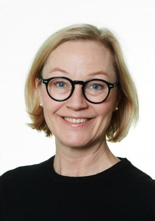 Cecilia Blomqvist tittar rakt in i kameran. Hon har halvlångt ljust hår, glasögon med mörka bågar och en mörk tröja.