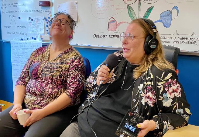 Eva Marie sitter med mikrofonen i högsta hugg och bär hörlurar. Hon ställer precis en knivig fråga till Greta som blundar och håller huvudet bakåt med en koncentrerad min.