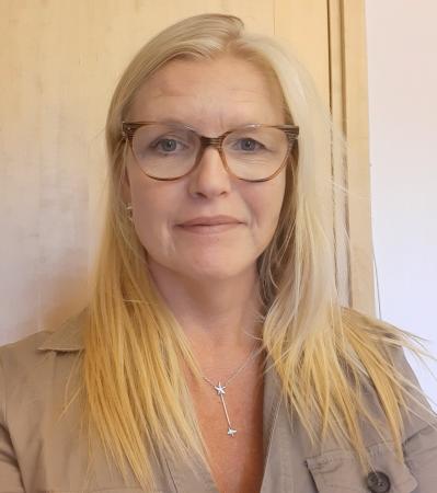 Siv Öhlund har långt, ljust hår och glasögon med ljusbruna bågar. Hon har en beigefärgad skjorta på sig.