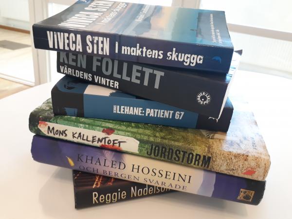 En trave böcker ligger på ett bord.