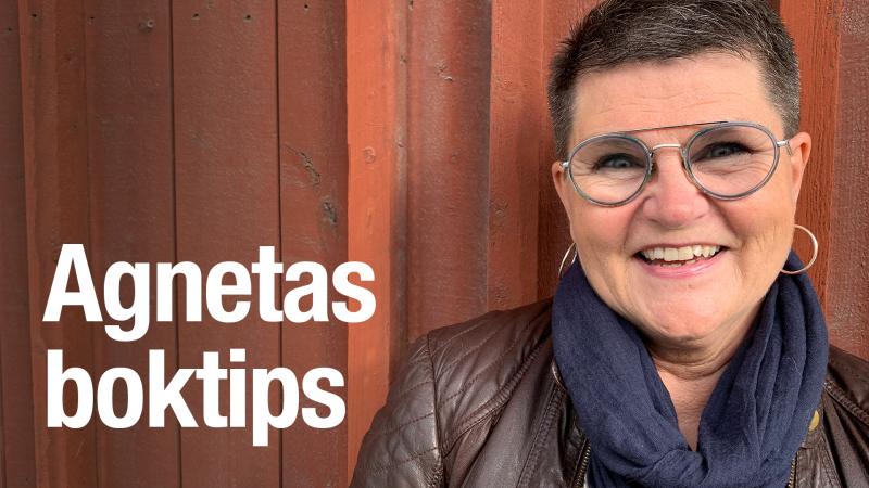 Agneta har mörkt, kort hår, glasögon med mörka bågar och en brun skinnjacka. Hon står framför den faluröda väggen på Kulturens hus i Luleå. Agneta Krohn Strömshed