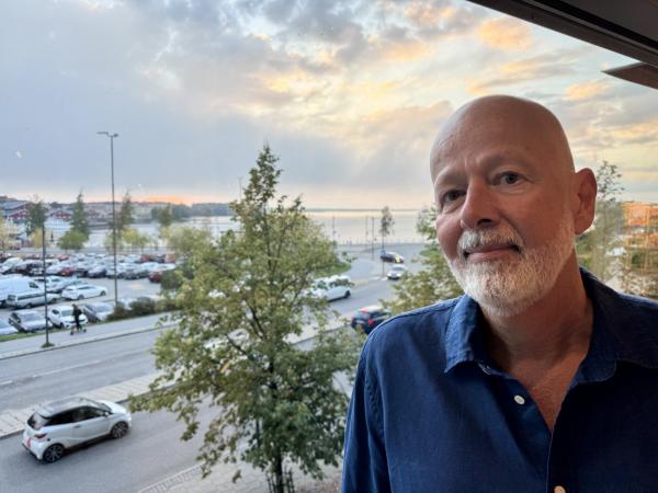 Anders är lång, har skägg men inget hår och ser glad ut. Han står med utsikt över norra hamn i Luleå. Anders Sundkvist