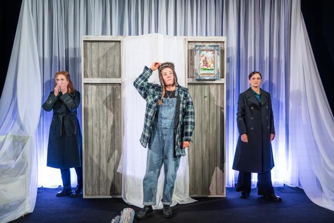 Tre kvinnor står på scenen i pjäsen Barndomshemmet. Barnddomshemmet
