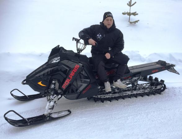 Man som sitter på en snöskoter.